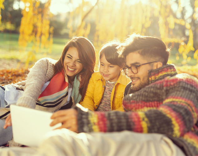 Man, woman, and boy looking at tablet